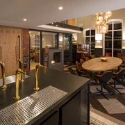 Privat-Brauerei Strate Detmold - Tastery Ein modern gestalteter Verkostungsraum mit edlen Zapfanlagen und stilvoller Möblierung in warmer Atmosphäre.