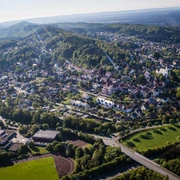 Luftbild Oerlinghausen Luftaufnahme von Oerlinghausen mit grünen Hügeln, dichter Bebauung und umliegenden Wäldern bei Sonnenschein.