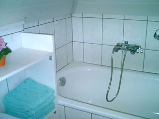 haus-rosen-bad Badewanne mit kleinem Regal daneben
