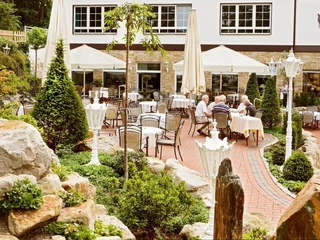 Kaffeekarten im Ringhotel Teutoburger Wald in Tecklenburg Brochterbeck Gepflegte Außenterrasse des Ringhotels Teutoburger Wald mit gedeckten Tischen und Sonnenschirmen.