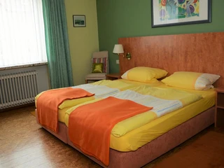 Modernes Ambiente im Hotel Mertens, Altenbeken Zweibettzimmer im Hotel Mertens mit hellen Farben, zwei bequemen Betten und gemütlicher Dekoration.