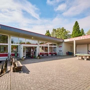 Aussenansicht Jugendherberge Bad Driburg Jugendherberge Bad Driburg mit Sonnenterrasse, Picknicktischen und großen Fenstern in modernem Design.