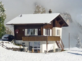 Vue extérieure du chalet en hiver Zweistöckiges Chalet in verschneiter UmgebungTwo-storey chalet in snowy surroundingsChalet à deux étages dans un environnement enneigé