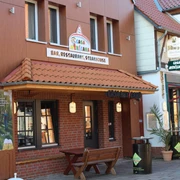 Mexikanisches Restaurant mit Holzfassade, rotem Ziegeldach, Holzbänken und Terrasse in einem Fachwerkgebäude.