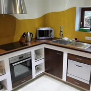 Eine moderne Küche mit Holzarbeitsplatte, ausgestattet mit Herd, Mikrowelle und Spülmaschine.