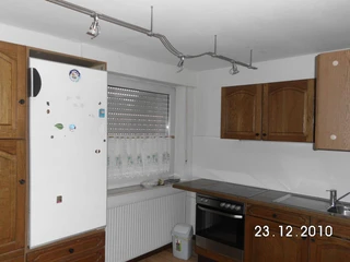 fewo-hausboemelburg-kueche Dunkle Eichenküche mit Einbaukühlschrank