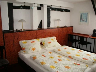 hotel-corveyerhof-doppelzimmer Doppelbett mit rückwärtiger Fachwerkwand