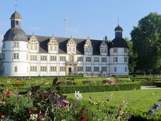 Schloß Neuhaus mit Barockgarten (Sommerbepflanzung) Schloss Neuhaus mit barockem Garten im Vordergrund, Sommerblumen blühen, blauer Himmel im Hintergrund.