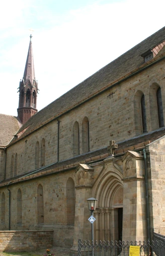 Kloster Loccum mit beeindruckender romanischer Architektur und markantem Kirchturm im Vordergrund.