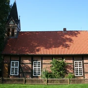 Fachwerkkapelle Anderten Historisches Fachwerkgebäude mit Glockenturm, roten Dachziegeln und weißen Sprossenfenstern.