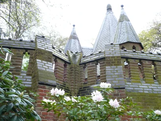 Mausoleum Etelser Schlosspark Backsteinmausoleum mit gefliesten spitzen Dächern vor blühendem Rhododendron im Schlosspark.