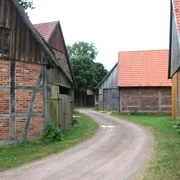 Scheunenviertel Schlüsselburg Eine gepflasterte Straße schlängelt sich durch ein historisches Ensemble aus Fachwerkscheunen.