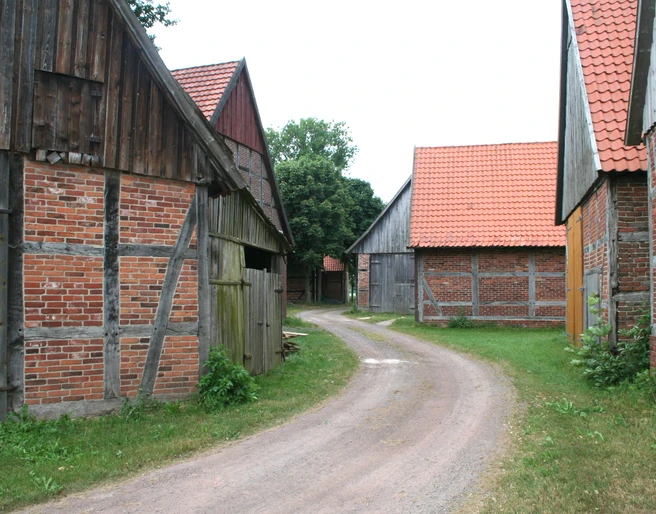 Scheunenviertel Schlüsselburg Eine gepflasterte Straße schlängelt sich durch ein historisches Ensemble aus Fachwerkscheunen.