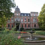Schlosspark Etelsen Historisches Schloss mit Grünanlage und zentralem Springbrunnen, umgeben von gepflegtem Park.