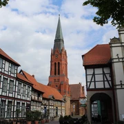 Pfarrkirche St. Martin in Nienburg umgeben von Fachwerkbauten, unter bewölktem Himmel.