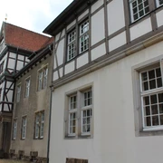 Altes Amtsgericht Petershagen Fachwerkgebäude mit weißen und grauen Wänden sowie roten Dachziegeln und vielen Fenstern in Petershagen.