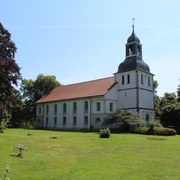 Weiße Kirche mit grauen Schindeln in grüner Parklandschaft unter blauem Himmel in Blender.