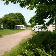 Wohnmobilstellplatz am Schloss Erbhof Wohnmobilstellplatz am Schloss Erbhof im Grünen, mit mehreren geparkten Wohnmobilen und Bäumen.