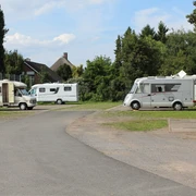 Wohnmobilstellplatz Petershagen Wohnmobilstellplatz in Petershagen mit mehreren geparkten Wohnmobilen, umgeben von Bäumen und Grünflächen.