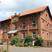 Meyersicksche Mühle Steyerberg Historische Backsteinmühle in Steyerberg umgeben von Natur, mit leicht bewölktem Himmel im Hintergrund.