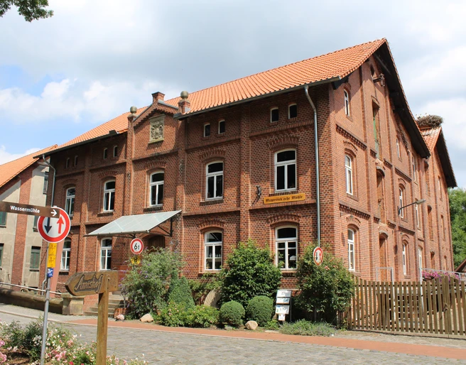 Meyersicksche Mühle Steyerberg Historische Backsteinmühle in Steyerberg umgeben von Natur, mit leicht bewölktem Himmel im Hintergrund.