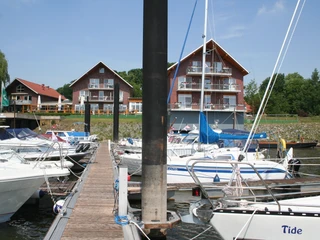 Uesener Hafen Achim Mehrere Boote liegen an Holzstegen vor einem Backsteingebäude mit Balkonen im Uesener Hafen Achim.