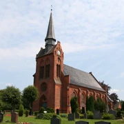 Kirche St. Georg in Eitzendorf Backsteinkirche St. Georg in Eitzendorf mit markantem Turmspitz, umgeben von grüner Landschaft.