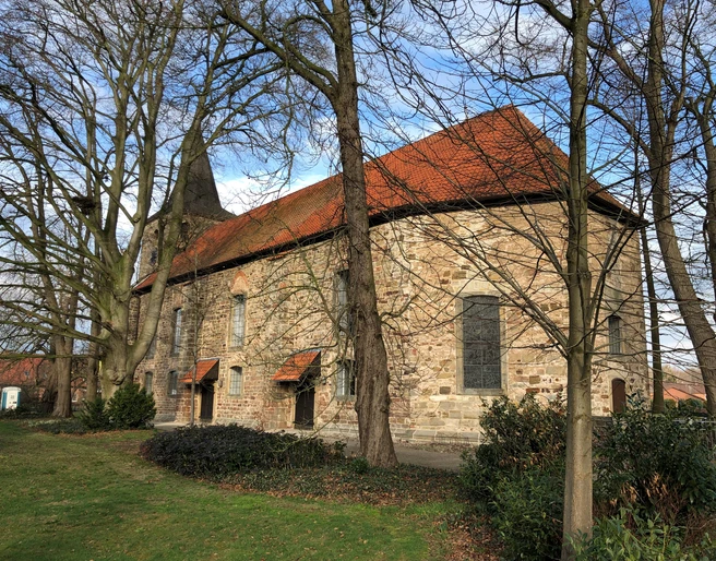Kirche Nendorf Historische Steinkirche mit rotem Ziegeldach und Turm, umgeben von kahlen Bäumen an einem klaren Tag.