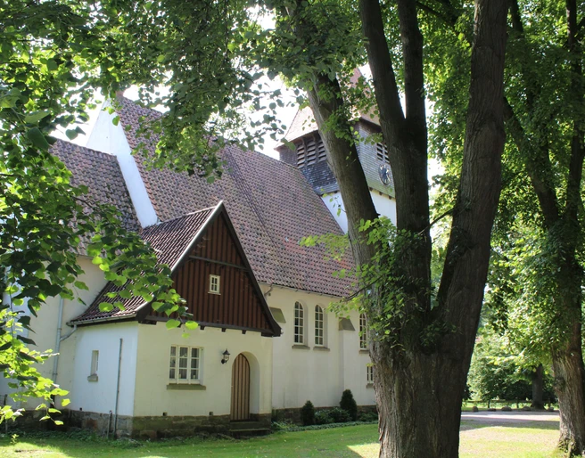 Kirche Raddestorf Eingebettet in üppiges Grün erhebt sich die historische Kirche Raddestorf mit ihrem markanten Glockenturm.