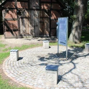 Kalibergbau Hülsen Ein traditionelles Kalibergbaumuseum mit Infotafel, umrandet von grünen Wiesen und Schattenspender.