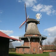 Feldmühle Martfeld Feldmühle Martfeld: Historische Windmühle aus Backstein und Holz in ländlicher Umgebung unter blauem Himmel.