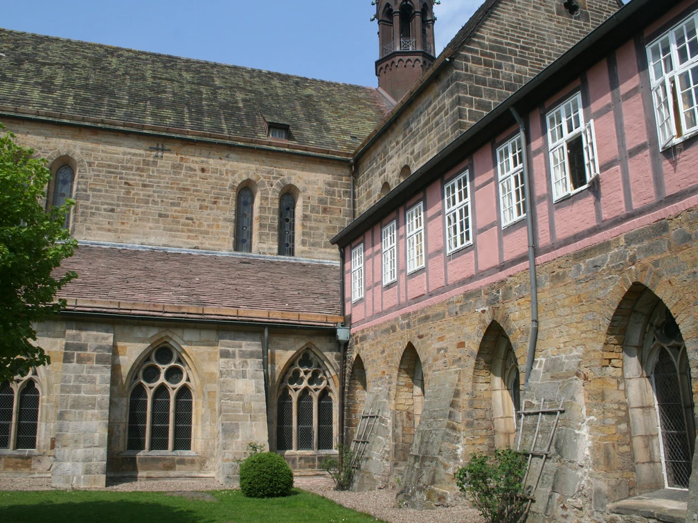 Kloster Loccum mit gotischen Fenstern und eleganten Backsteinfassaden vor einem klaren Himmel.
