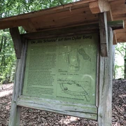 Alte Schanze Oyler Berg Infotafel im Wald mit historischem Plan und Text zur "Alten Schanze" auf dem Oyler Berg im Hintergrund.