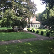 Schloss Rheder mit seinem beeindruckenden Herrenhaus umgeben von gepflegten Gärten und alten Bäumen.