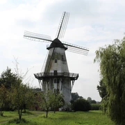 Windmühle Lavelsloh Windmühle in Lavelsloh mit markantem Flügelrad, umgeben von Bäumen und grüner Landschaft.