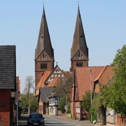 SG Grafschaft Hoya Stiftskirche Bücken Zwei beeindruckende Kirchtürme ragen in den Himmel über der schläfrigen Straße in Bücken.