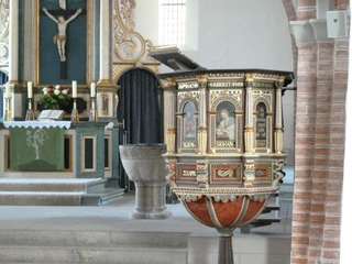 St. Laurentius-Kirche Achim Innenansicht Ein kunstvoll verzierter hölzerner Kanzelkorb mit biblischen Szenen, umrahmt von Altarbereich und Taufbecken.