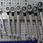 Verschiedene Schraubenschlüssel hängen ordentlich an einer Lochwand, bereit für den Einsatz in der Werkstatt.