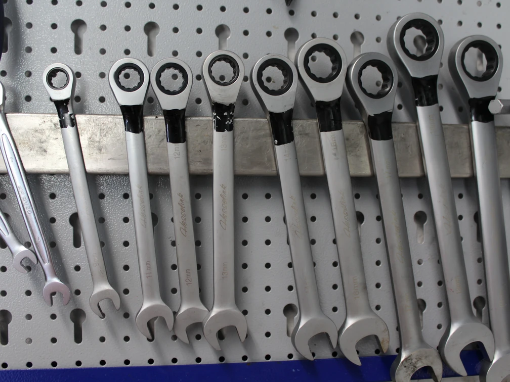Schraubenschlüssel Verschiedene Schraubenschlüssel hängen ordentlich an einer Lochwand, bereit für den Einsatz in der Werkstatt.