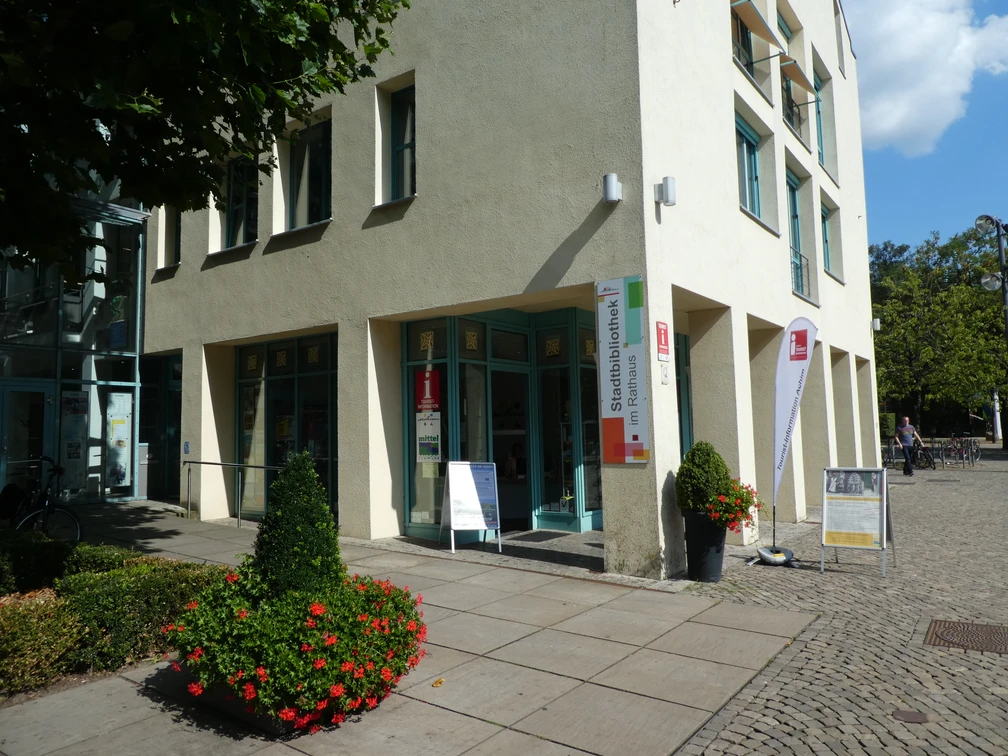 Tourist-Information Achim Eingang der Tourist-Information Achim, einladend dekoriert mit Blumenkübeln und Infotafeln.