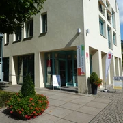 Tourist-Information Achim Eingang der Tourist-Information Achim, einladend dekoriert mit Blumenkübeln und Infotafeln.
