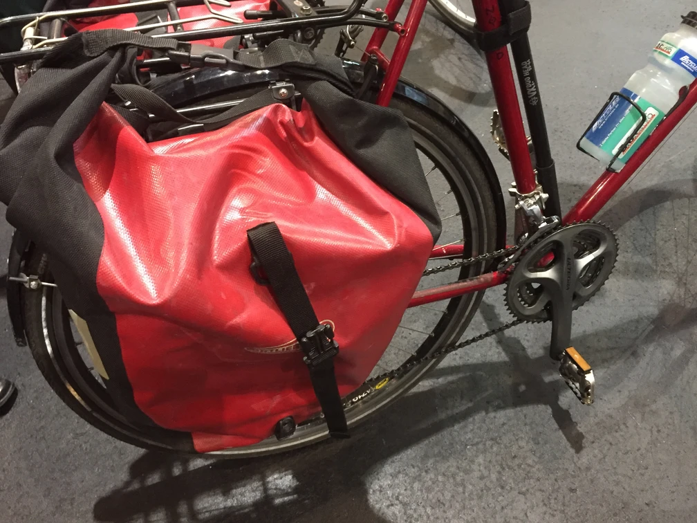 Fahrradtasche Rote Fahrradtasche aus wasserdichtem Material an einem Fahrradrahmen, geschützt vor Regen.