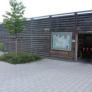 Fahrradstation Kirchweyhe Fahrradverleihstation mit Holzfassade, Informationsschild, Zugang zur Aufbewahrung von Fahrrädern.
