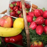Obst und Gemüse Frisches Obst und Gemüse arrangiert in einem Korb, darunter Banane, Erdbeeren, Radieschen.