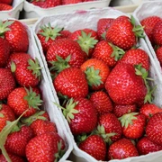 Erdbeeren Frische Erdbeeren in Obstkisten, leuchtend rot und appetitlich, mit grünen Stängeln.
