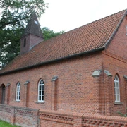 Kapelle Wendenborstel Rote Backsteinkapelle mit spitzem Turm, umgeben von Bäumen, Teil des Dorfes Wendenborstel.