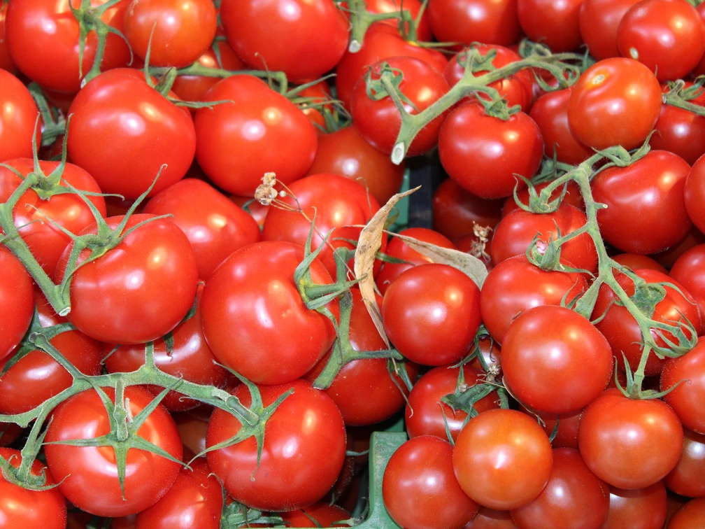 Tomaten Frische rote Tomaten mit grünen Stielen, dicht angeordnet, vermitteln ein lebendiges und gesundes Bild.