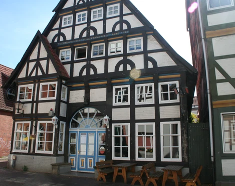 Bürgerhaus Fachwerk-Bürgerhaus mit auffälliger dreieckiger Giebelfront und blauer Tür in historischem Stil.