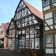 Bürgerhaus Fachwerkgebäude mit roten Ziegeldächern, typisch norddeutscher Stil, Straßenszene im Sonnenschein.