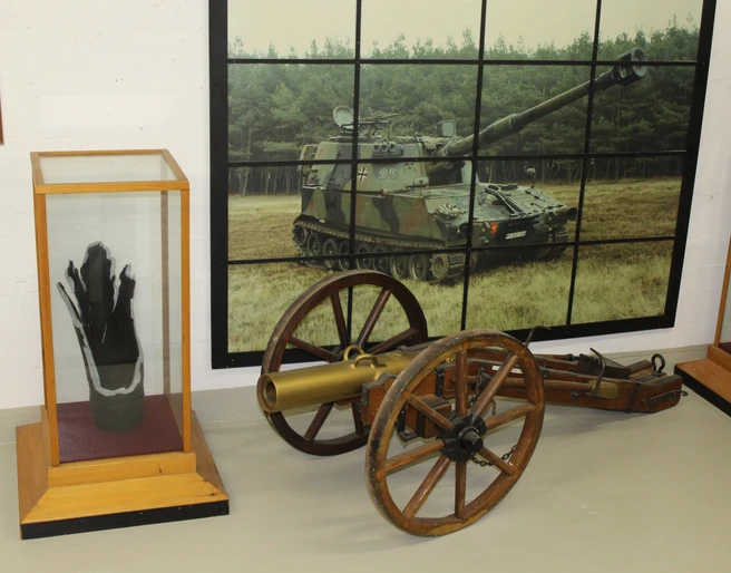 Militärhistorische Ausstellung Eine alte Kanone und moderne Panzerartillerie in einer militärhistorischen Ausstellung.
